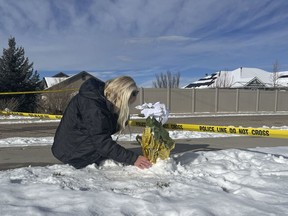 Sharon Huntsman, a member of The Church of Jesus Christ of Latter-day Saints from Cedar City, Utah, leaves flowers outside a home where eight family members were found dead in Enoch, Utah, Thursday, Jan. 5, 2023. Officials said Michael Haight, 42, took his own life after killing his wife, mother-in-law and the couple's five children.