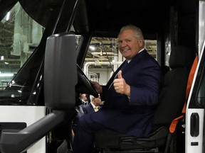 Ontario Premier Doug Ford sits behind the wheel of ZEVO 600 during the opening of Canada's first full-scale electric vehicle manufacturing plant, in Ingersoll, Ont., Dec. 5, 2022.