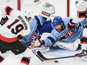 Ottawa Senators Drake Batherson (19) moves in on Montreal Canadiens' goaltender Jake Allen as Canadiens' David Savard attempts to block the shot during second period NHL hockey action in Montreal, Tuesday, Jan. 31, 2023.