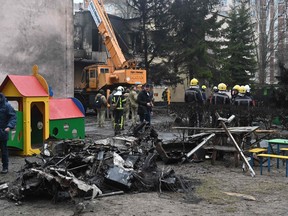 Firefighters work near the site where a helicopter crashed near a kindergarten in Brovary, outside the capital Kyiv, killing 18 people, including two children and Ukrainian interior minister, on January 18, 2023.