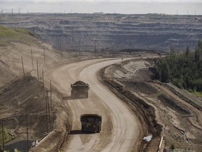 A heavy hauler truck transports in the oilsands in Fort McMurray Alta, on June 13, 2017. Alberta's New Democrat Opposition says a government review of the program that's supposed to ensure oilsands companies can clean up their mines was too private and should have been done in public.