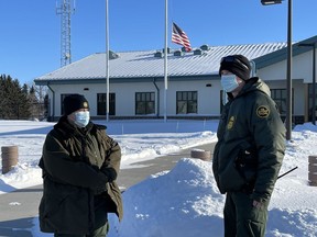 U.S. Border Patrol agents Katy Siemer, left and David Marcus stand outside the Customs and Border Protection facility in Pembina, N.D., on Tuesday, Jan. 25, 2022.