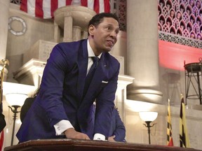 Ivan Bates looks up after adding his signature, to acknowledge the thunderous applause in the packed War Memorial Building upon his becoming Baltimore City's new State's Attorney, Tuesday, Jan. 3, 2023, in Baltimore.
