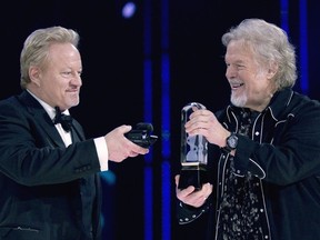 FILE - Randy Bachman, right, holds the Juno as Robbie Bachman videotapes a closeup of the trophy after being inducted into the Canadian Music Hall of Fame at the Juno Awards in Winnipeg on March 30, 2014. Robbie Bachman, the drummer for the Canadian hard rock band Bachman-Turner Overdrive that was known for such 1970s hits as "Takin' Care of Business" and "You Ain't Seen Nothin' Yet," has died at age 69. His death was announced on social media Thursday by his brother and bandmate, Randy Bachman, who did not cite a cause.
