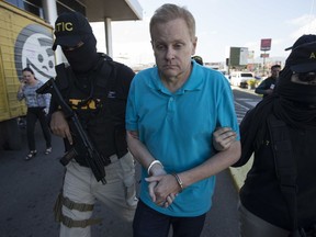 FILE - Prior to his extradition, Eric Conn is escorted by SWAT team agents at the Toncontin International Airport in Tegucigalpa, Honduras, Dec. 5, 2017. Conn, a fugitive Kentucky lawyer who escaped before facing sentencing for his central role in a massive Social Security fraud case, was captured the day prior as he came out of a restaurant in the coastal city of La Ceiba. Now, some former clients of the disgraced Kentucky attorney who ran the largest U.S. Social Security scam in history may have a chance to get their lost disability payments back.