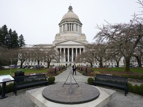 FILE - The sun dial near the Legislative Building is shown under cloudy skies, March 10, 2022, at the state Capitol in Olympia, Wash. An effort to balance what is considered the nation's most regressive state tax code comes before the Washington Supreme Court on Thursday, Jan. 26, 2023, in a case that could overturn a prohibition on income taxes that dates to the 1930s.