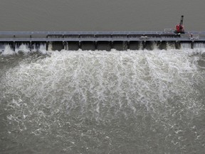 FILE - Workers open bays of the Bonnet Carre Spillway to divert rising water from the Mississippi River to Lake Pontchartrain, upriver from New Orleans, in Norco, La., May 10, 2019. A federal judge ruled Wednesday, Jan. 18, 2023, that the U.S. Army Corps of Engineers must consult with federal fisheries experts on the effects of opening the spillway that helped prevented Mississippi River flooding in New Orleans, but caused damage to coastal Mississippi marine life and tourism in 2019.