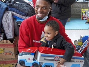 FILE - Pittsburgh NCAA college football defensive back Damar Hamlin poses for a photo with Bryce Williams, 3, of McKees Rocks, Pa., after the youngster picked out a toy during Hamlin's Chasing M's Foundation community toy drive at Kelly and Nina's Daycare Center, Tuesday, Dec. 22, 2020, in McKees Rocks, Pa. Buffalo Bills safety Damar Hamlin plans to support young people through education and sports with the $8.6 million in GoFundMe donations that unexpectedly poured into his toy drive fundraiser after he suffered a cardiac arrest in the middle of a game last week.