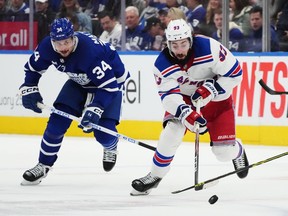Toronto Maple Leafs forward Auston Matthews (34) chases New York Rangers forward Mika Zibanejad (93) during third period NHL hockey action in Toronto on Wednesday, January 25, 2023. Matthews will miss at least three weeks with a knee sprain, the team announced Friday.