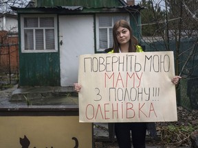 Alina Kapatsyna holds a poster that reads: 'Bring back my mom from captivity,' written in Ukrainian, in Dnipro, Ukraine, Jan. 6.