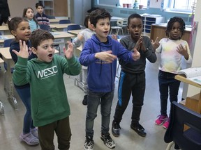 Students sing a song during French integration class for new arrivals, Wednesday, Jan. 25, 2023, in Montreal.