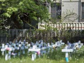 A panel of experts with the Health Standards Organization has developed updated guidance for how care homes should operate in light of the deadly and tragic toll the pandemic took on Canadian residents and their quality of life. A man looks out the window at the Camilla Care Community centre overlooking crosses marking the deaths of multiple people that occurred during the COVID-19 pandemic in Mississauga, Ont., on May 26, 2020.