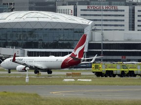 A Qantas jet is parked on the tarmac next to firetrucks at Sydney International Airport after making an emergency landing in Sydney, Wednesday, Jan. 18, 2023. The Qantas flight traveling from New Zealand to Sydney landed safely after it issued a mayday call over the Pacific Ocean.