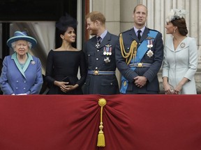FILE - In this Tuesday, July 10, 2018 file photo Britain's Queen Elizabeth II, and from left, Meghan the Duchess of Sussex, Prince Harry, Prince William and Kate the Duchess of Cambridge watch a flypast of Royal Air Force aircraft pass over Buckingham Palace in London. Prince Harry has said he wants to have his father and brother back and that he wants "a family, not an institution," during a TV interview ahead of the publication of his memoir. The interview with Britain's ITV channel is due to be released this Sunday.