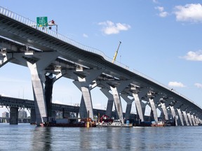 A recently released Quebec coroner report says that Montreal's Champlain Bridge needs to improve its safety barrier, after a 38-year-old man jumped to his death from the structure in May 2022. The Samuel de Champlain bridge is seen with the old bridge in the background in Montreal on Monday, June 17, 2019.