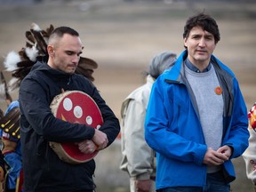Prime Minister Justin Trudeau speaks as Williams Lake First Nation Chief Willie Sellars, left, listens during a visit to the former grounds of St. Joseph's Mission Residential School, in Williams Lake, B.C., on Wednesday, March 30, 2022. The chief says he would support excavating possible unmarked graves found at the site if that's what elders and the community decide is best.THE CANADIAN PRESS/Darryl Dyck