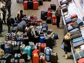 Luggage bags are amassed in the bag claim area at Toronto Pearson International Airport, as a major winter storm disrupts flights in and out of the airport, in Toronto, Saturday, Dec. 24, 2022.