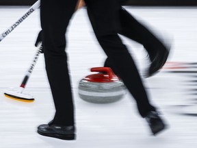A stone slides down the sheet at the World Men's Curling Championship in Calgary, Alta., Tuesday, April 6, 2021. Melvin Lee's first call to curl with a diverse team of law students came more than two decades ago. Now, the avid curler has a wealth of experience behind him. And he tries to give a similar welcome to others who are underrepresented in sports.
