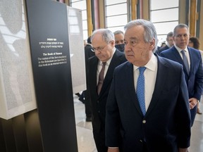 Antonio Guterres, United Nations Secretary General, center, Dani Dayan, Chairman of Yad Vashem, left, and Gilad Erdan, Permanent Representative of Israel to the United Nations, right, walk along the Yad Vashem Book of Names of Holocaust Victims Exhibit, Thursday, Jan. 26, 2023, at United Nations headquarters.