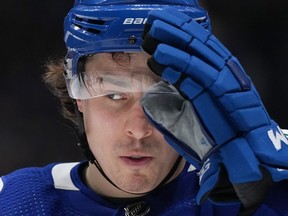 Vancouver Canucks' Andrei Kuzmenko, of Russia, adjusts his visor prior to a faceoff during the third period of an NHL hockey game against the Colorado Avalanche in Vancouver, on Thursday, Jan. 5, 2023.