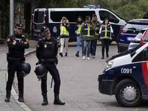 FILE - Police officers stand guard as other officers in yellow vests walk back at the cordoned off area next to the Ukrainian embassy in Madrid, Spain, Wednesday, Nov. 30, 2022 following reports of a blast at the Ukrainian embassy. Spain's National Court said Friday, Jan. 27, 2023, it had charged a 74-year-old retired man with terrorism after he allegedly sent six letters containing explosive material to Spain's prime minister and the U.S. and Ukrainian embassies in the country.