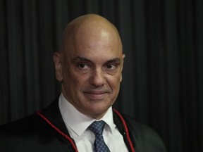 FILE - Judge Alexandre de Moraes stands as he is sworn in as the new head of the Supreme Electoral Tribunal, the government body that oversees elections, ahead of the Oct. 2 elections in Brasilia, Brazil, Aug. 16, 2022. De Moraes has been aggressively pursuing those suspected of undermining Brazil's democracy, whether it's investigating former President Jair Bolsonaro, arresting protesters on slim evidence or banishing some people from social media after they were accused of spreading conspiracy theories.