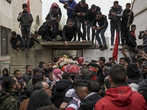 Mourners carry the body of 14-year-old Palestinian Omar Khumour during his funeral in the West Bank city of Bethlehem, Monday, Jan. 16, 2023. The Palestinian Health Ministry said Khumour died after being struck in the head by a bullet during an Israeli military raid into Dheisha refugee camp near the city of Bethlehem. The Israeli army said that forces entered the Dheisha camp and were bombarded by Molotov cocktails and rocks. It said soldiers responded to the onslaught with live fire.