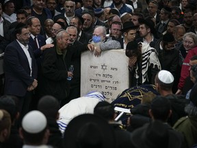 Mourners attend the funeral of Israeli couple Eli Mizrahi and his wife, Natalie, victims of a shooting attack Friday in east Jerusalem, at the cemetery in Beit Shemesh, Israel, early Sunday, Jan. 29, 2023. On Friday a Palestinian gunman opened fire outside an east Jerusalem synagogue, killing the couple and another five people, including a 70-year-old woman, and wounding three others before he was shot and killed by police, officials say. It was the deadliest attack on Israelis since 2008 and raised the likelihood of more bloodshed.