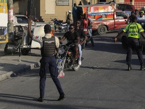 National police control security on a street in Port-au-Prince, Haiti, Saturday, Jan. 21, 2023. One of Haiti's gangs stormed a key part of the capital, Port-Au-Prince, and battled with police throughout the day, leaving at least three officers dead and another missing.