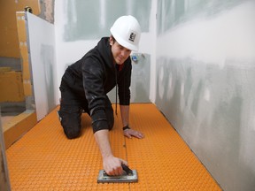 Michael installing uncoupling membrane as part of the electric in-floor heating system in a recent bathroom renovation.