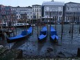 This photograph taken on February 20, 2023, shows gondolas tied up in Venice Canal Grande, during a severe low tide in the lagoon city of Venice.