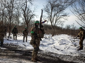 Ukrainian soldiers gather at a road outside the frontline town of Bakhmut in Donetsk region, Ukraine, February 13, 2023.