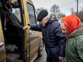 Ukrainian residents board an evacuation bus on February 28, 2023, amid  heavy shelling in Bakhmut.