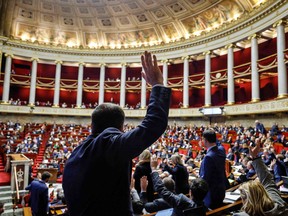MPs hold a vote by show of hands during a session to discuss the government's pensions reform plan at the National Assembly, France's Lower House of Parliament, in Paris, February 14, 2023.