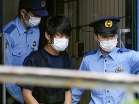 Tetsuya Yamagami, who's suspected of killing former Japanese premier Shinzo Abe, is escorted by police officers at Nara-nishi police station in Nara, Japan, on July 10, 2022.