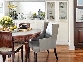 Vintage dining chairs and an antique table are modernized with contemporary upholstery fabric and a protective stone top in Karl Lohnes’ dining room.