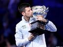 Novak Djokovic of Serbia poses with the Norman Brookes Challenge Cup after winning the Australian Open for his 10th time on Jan. 29, 2023. Australian authorities prevented the tennis phenom from competing in the open last year, deporting him because of his unvaccinated status.