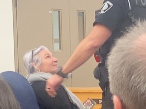 Transgendered teacher's dress complaints unsettled after fiery Ontario school board meeting A woman is removed from the school board meeting by police. (Photo credit: Students First Ontario)
