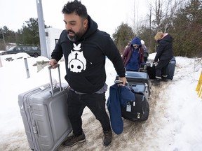 A family of asylum seekers from Colombia crosses the border at Roxham Road into Quebec from Champlain, N.Y., on February 9, 2023.