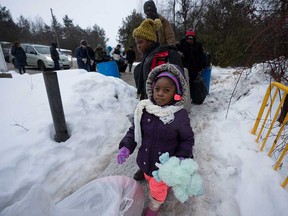 Asylum seekers from the Democratic Republic of Congo cross the Canada-U.S. border into Quebec at Roxham Road in Champlain, N.Y., on Feb. 9, 2023.