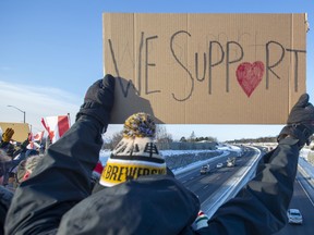 Supporters cheer from an overpass as trucks pass as part of the Freedom Convoy headed for Ottawa, in Kingston, Ont., January 28, 2022.