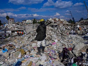 A man stands on the rubble of collapsed buildings in Hatay, Turkey, on Feb. 10, 2023, after a 7.8-magnitude earthquake struck the country's southeast and portions of Syria.