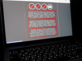 A laptop screen displays a warning message in Ukrainian, Russian and Polish, that appeared on the official website of the Ukrainian Foreign Ministry after a massive cyberattack, in this illustration taken January 14, 2022. REUTERS/Valentyn Ogirenko/Illustration/File Photo