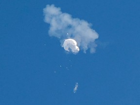 A suspected Chinese spy balloon drifts to the ocean after being shot down off the coast of Surfside Beach, S.C., on Feb. 4.