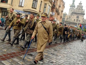 A veteran of the Ukrainian Insurgent Army (UPA) marches with people dressed as UPA soldiers on Oct. 11, 2009, in the western Ukrainian city of Lviv to mark the 67th anniversary of the founding of UPA in 1943.