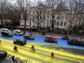 LONDON, ENGLAND - FEBRUARY 23: In this handout provided by Led By Donkeys, Activists from political campaign group Led By Donkeys, pour paint onto the road to create a giant Ukrainian flag outside the Russian Embassy on February 23, 2023 in London, England.