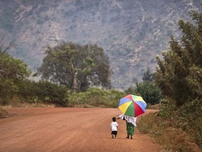 FILE - A mother reaches out to hold the hand of her young daughter, as they walk home after a church service in the village of Rwinkwavu, near to Akagera National Park, in Rwanda on Sept. 6, 2015. The Protestant Council of Rwanda in Feb. 2023 has directed all health facilities run by its members to stop carrying out all abortions, further limiting access to the procedure in the largely Christian nation of 13 million people.