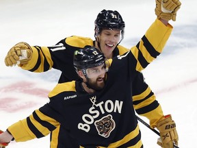 Boston Bruins' Nick Foligno (17) celebrates after his goal with Taylor Hall (71) during the second period of an NHL hockey game against the Washington Capitals, Saturday, Feb. 11, 2023, in Boston.