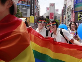 FILE - Participants smile as they march with a banner during the Tokyo Rainbow Pride parade celebrating the lesbian, gay, bisexual, and transgender (LGBT) community in Tokyo's Shibuya district, May 7, 2017. Prime Minister Fumio Kishida told reporters Saturday, Feb. 4, 2023, that one of his senior aides is being dismissed after making discriminatory remarks about LGBTQ people.