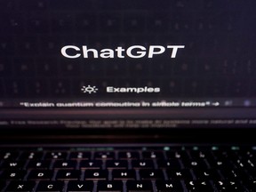 A keyboard is seen reflected on a computer screen displaying the website of ChatGPT.